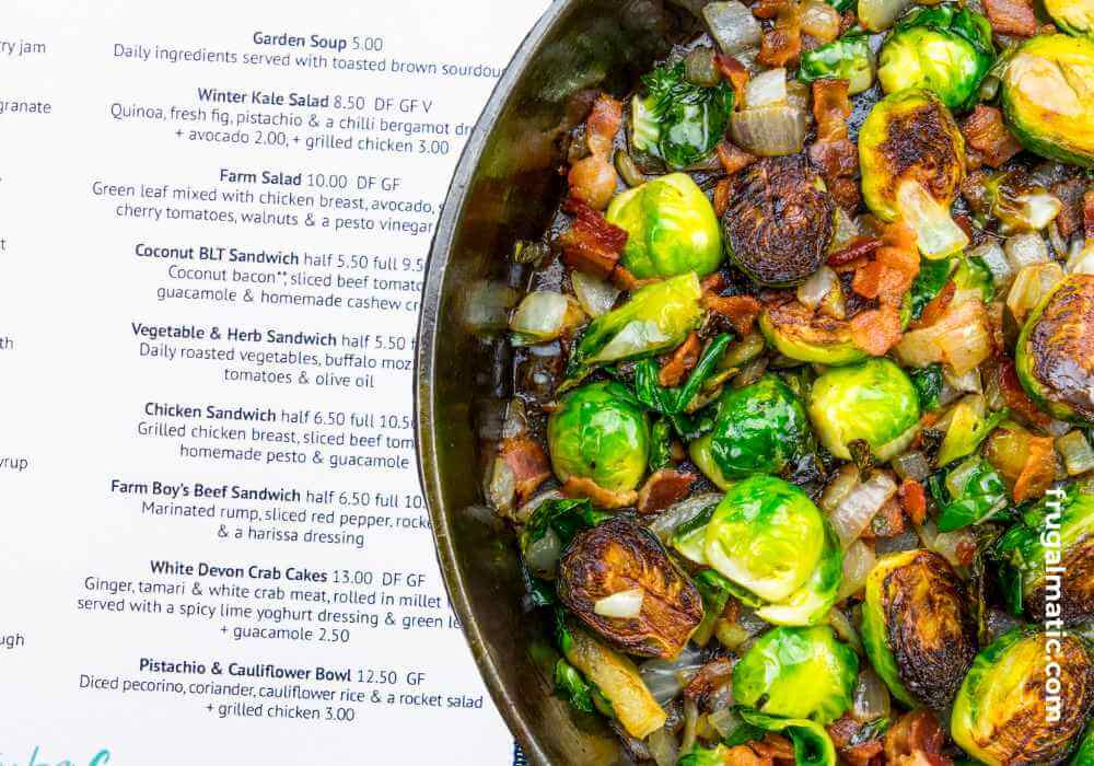 Bowl of roasted vegetables with menu in background